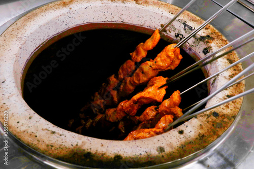 Quadro su tela spice marinated chicken cubes ( chicken tikka )skewers cooking in a clay oven kn
