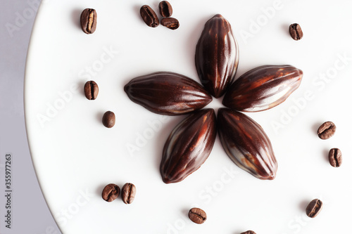 Handcrafted dark chocolate, on white background with coffee beans. Top view of single origin coffee mixed with chocolate.