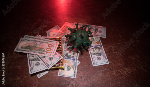 Corona virus miniature and money on wooden table with fog and backlight. Creative artwork decoration. Selective focus.