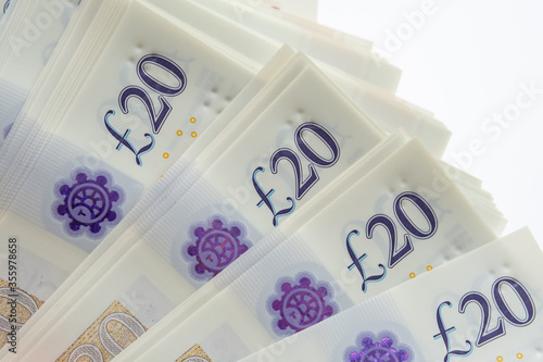 Corner of the stack of 20 pound banknotes isolated on white. Photo of new polymer 20 pound note released in februrary 2020 in the United Kingdom. photo