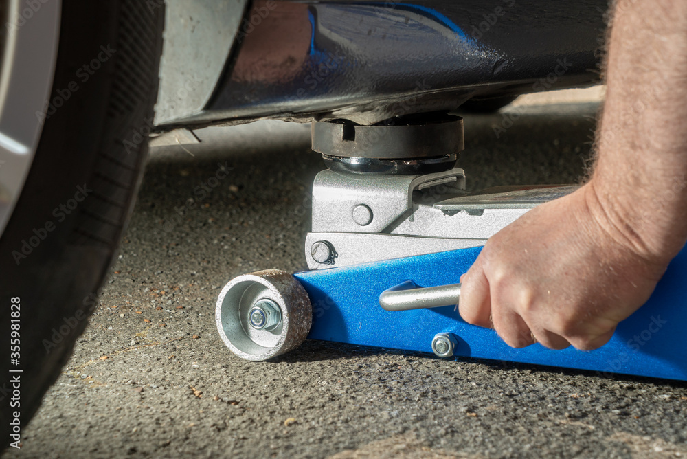 Adjust a hydraulic jack under a car