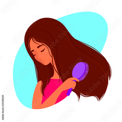 Beautiful woman combing her long hair with a comb.