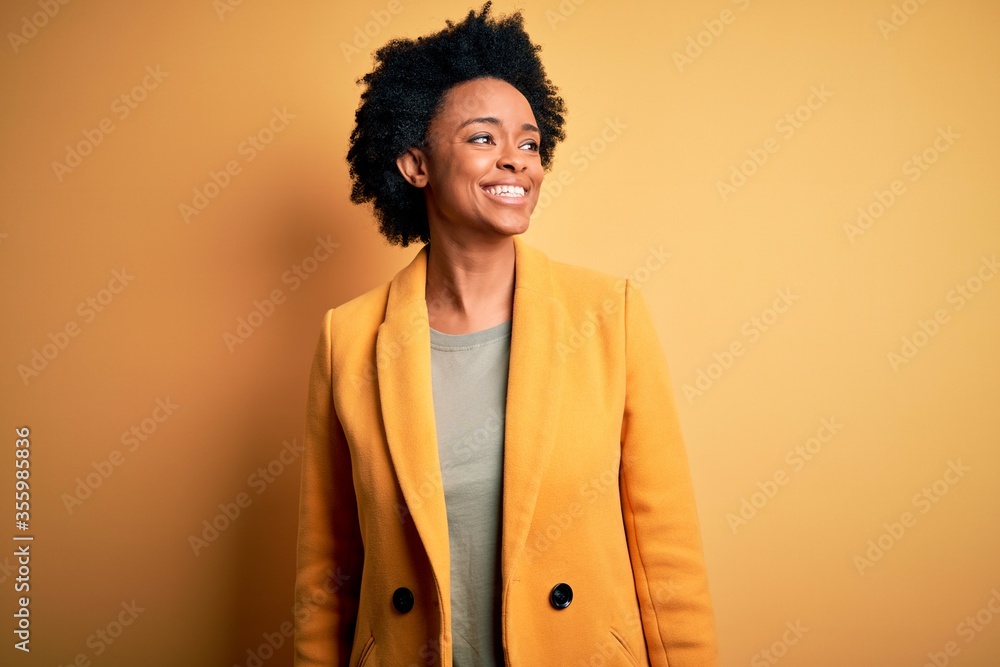 © Krakenimages.com - Young beautiful African American afro businesswoman with curly hair wearing yellow jacket looking away to side with smile on face, natural expression. Laughing confident. © Krakenimages.com - Young beautiful African American afro businesswoman with curly hair wearing yellow jacket looking away to side with smile on face, natural expression. Laughing confident.