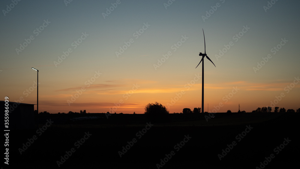 Obraz premium Wind generator at sunset on a warm day