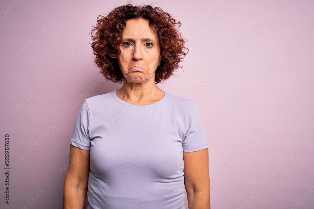 Middle age beautiful curly hair woman wearing casual t-shirt over isolated pink background depressed and worry for distress, crying angry and afraid. Sad expression. Middle age beautiful curly hair woman wearing casual t-shirt over isolated pink background depressed and worry for distress, crying angry and afraid. Sad expression.