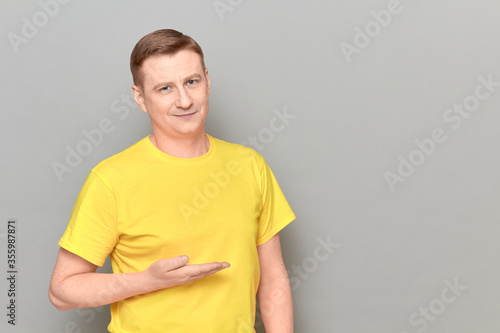 Portrait of happy man pointing with hand at empty place and smiling
