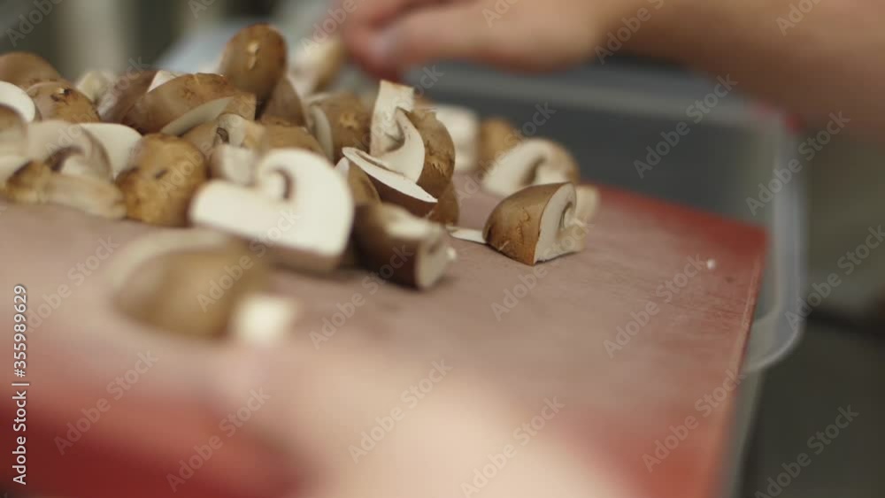chef chopping mushrooms in kitchen table restaurant slow motion