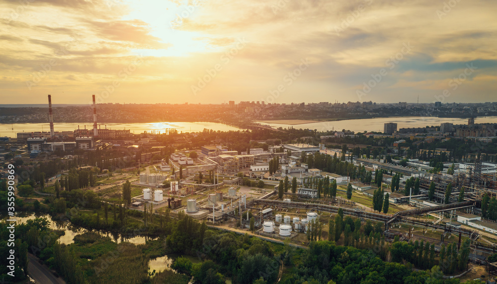 Sunset over European city industrial zone with factories, aerial panorama.