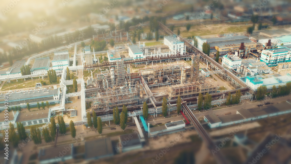 Aerial view of Chemical factory with tanks storages steel pipelines, industrial zone area, tilt-shift view like little toy buildings with blurred background.