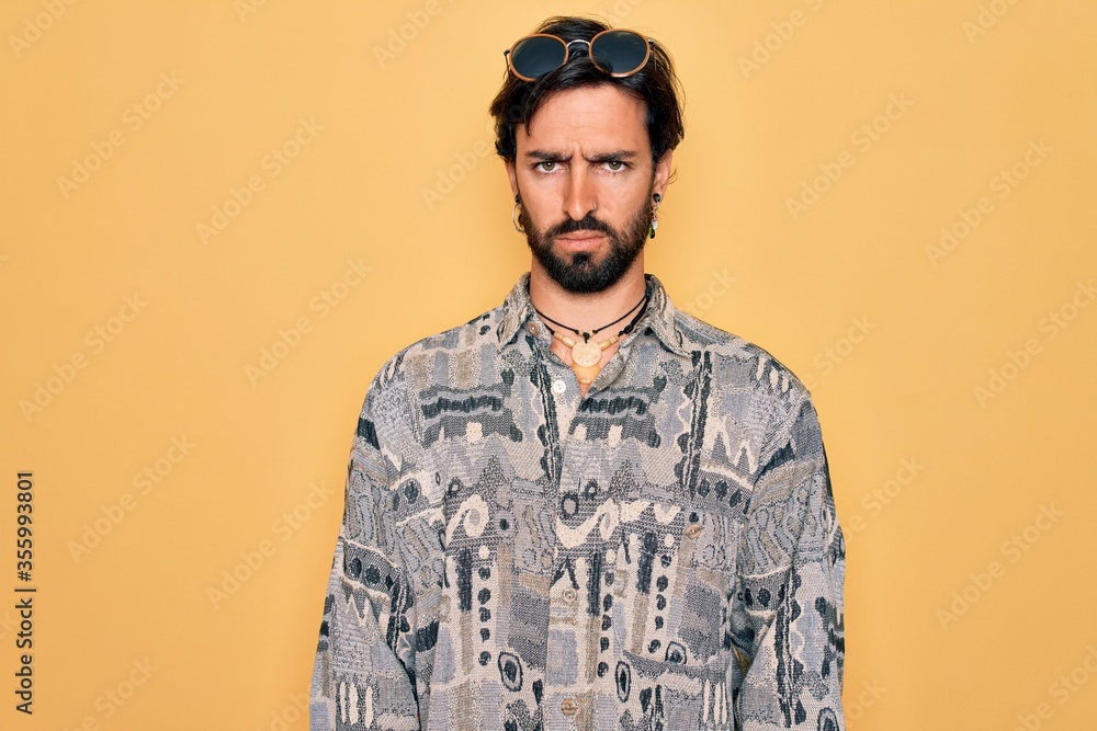 Young handsome hispanic bohemian man wearing hippie style and sunglasses skeptic and nervous, frowning upset because of problem. Negative person. Young handsome hispanic bohemian man wearing hippie style and sunglasses skeptic and nervous, frowning upset because of problem. Negative person.