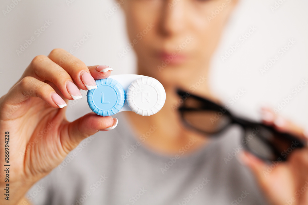 Fototapeta premium Woman holding a container with contact lenses