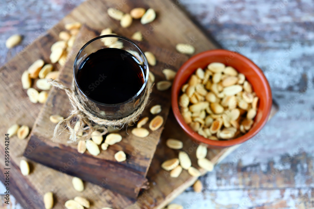 Selective focus. A glass of coca cola and peanuts. Salted peanuts in a