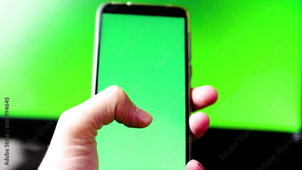 Segurando celular com fundo em verde