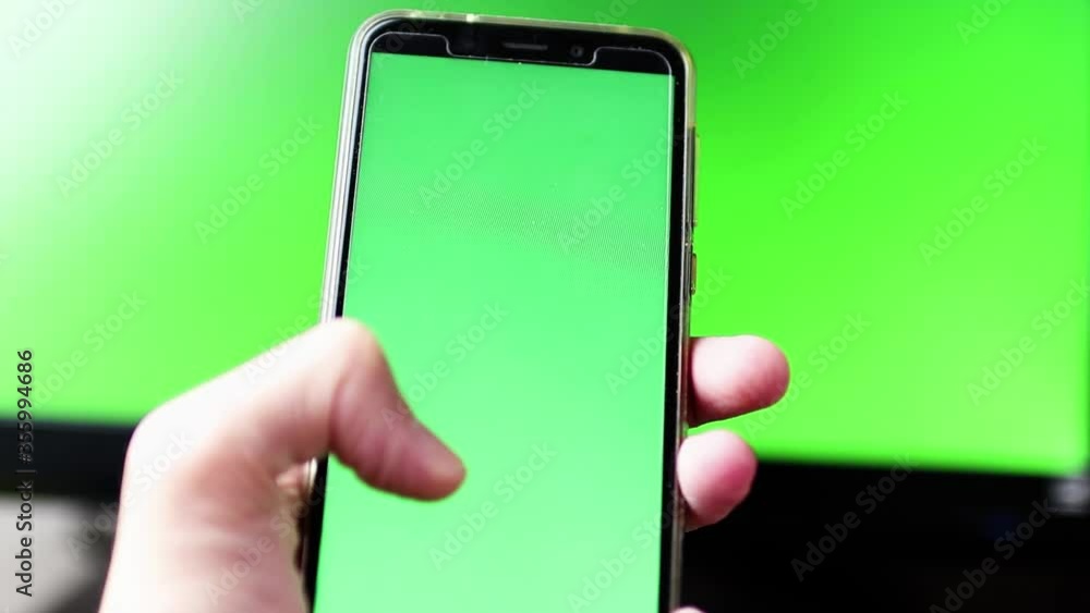 Segurando celular com fundo em verde