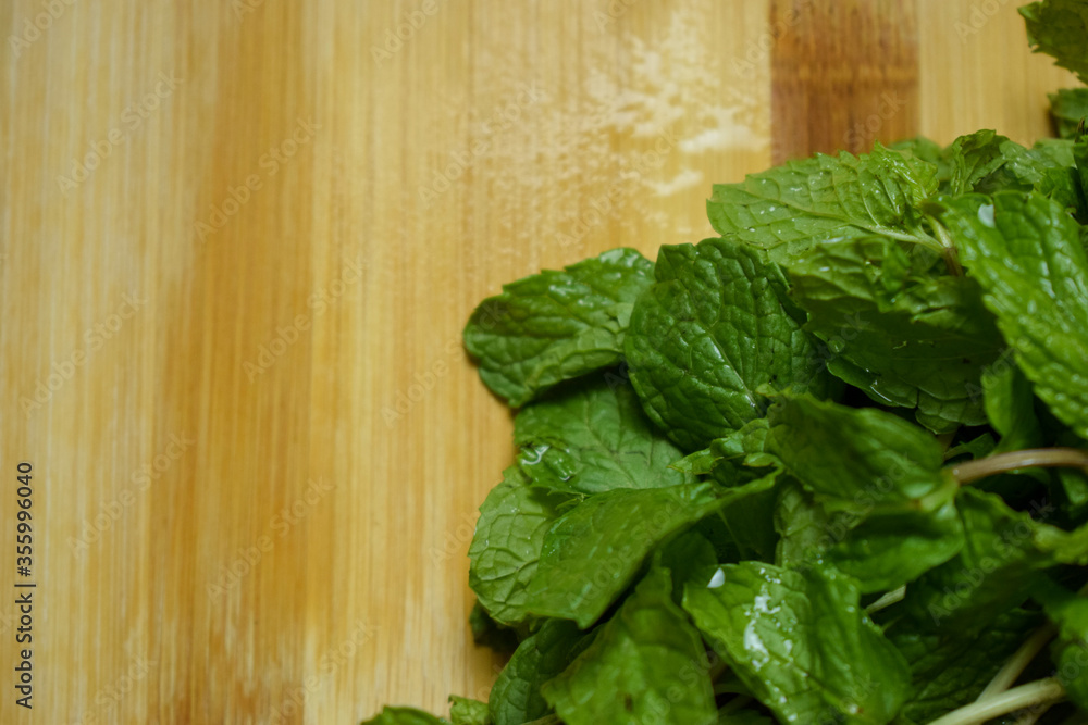 Fresh Mint Leafs Bunch on Brown wooden Table Fresh Mint Leafs Bunch on Brown wooden Table
