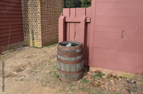 wood barrel with metal rings and red bricks and red wall