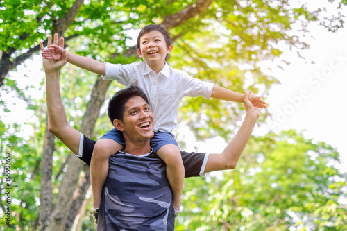 Happy and enjoy Asian Father and son having fun in summer park
