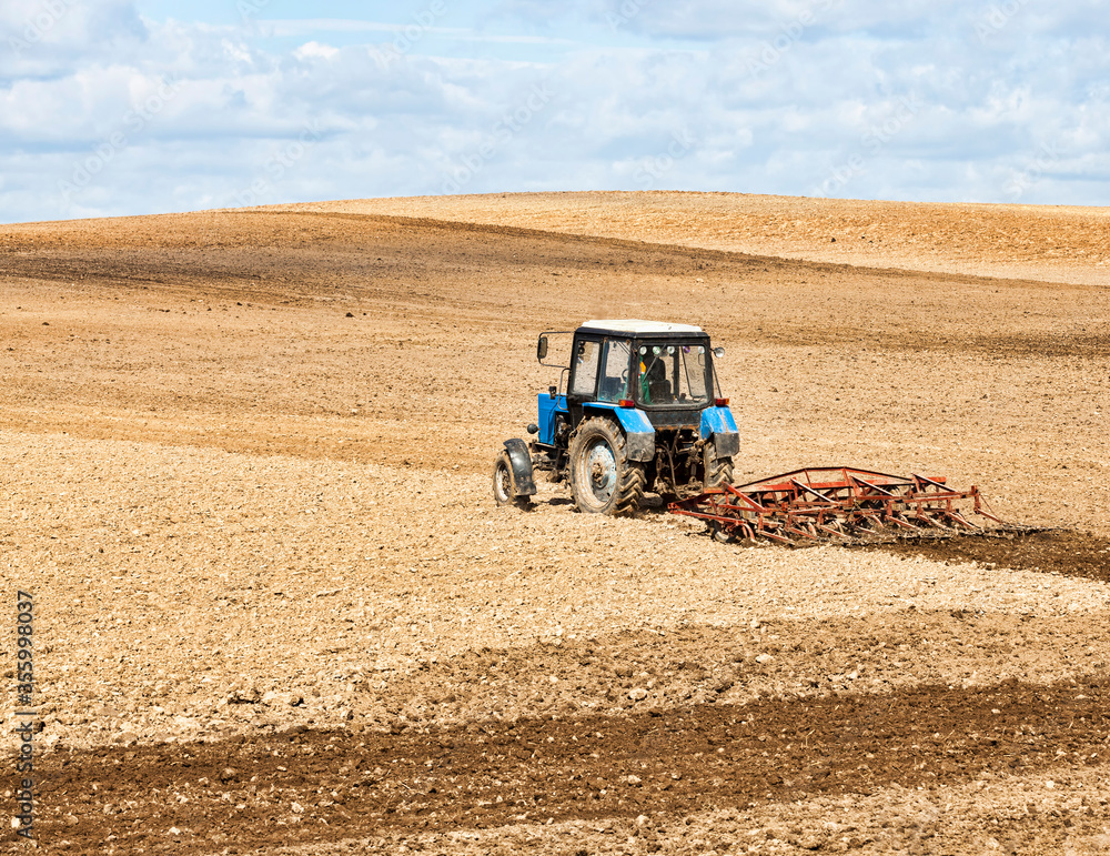 Obraz premium an old tractor plows the soil