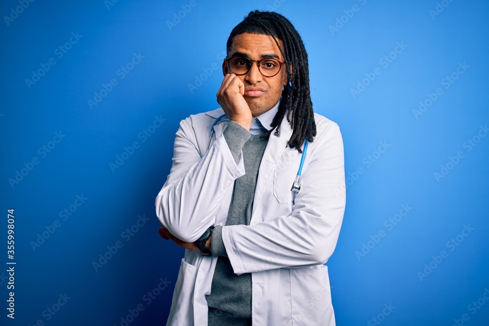 Young african american doctor man with dreadlocks wearing stethoscope and glasses thinking looking tired and bored with depression problems with crossed arms. Young african american doctor man with dreadlocks wearing stethoscope and glasses thinking looking tired and bored with depression problems with crossed arms.
