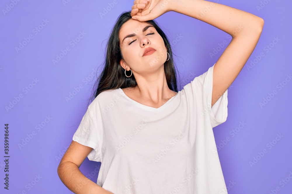 Young beautiful brunette woman wearing casual white t-shirt over purple background stretching back, tired and relaxed, sleepy and yawning for early morning Young beautiful brunette woman wearing casual white t-shirt over purple background stretching back, tired and relaxed, sleepy and yawning for early morning