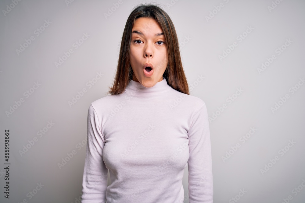Young beautiful brunette girl wearing casual sweater standing over isolated white background afraid and shocked with surprise expression, fear and excited face. Young beautiful brunette girl wearing casual sweater standing over isolated white background afraid and shocked with surprise expression, fear and excited face.