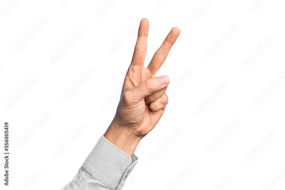 Hand of caucasian young man showing fingers over isolated white background counting number 2 showing two fingers, gesturing victory and winner symbol Hand of caucasian young man showing fingers over isolated white background counting number 2 showing two fingers, gesturing victory and winner symbol