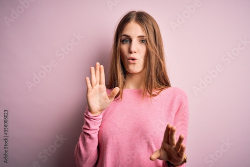 Wallpaper Mural Young beautiful redhead woman wearing casual sweater over isolated pink background Moving away hands palms showing refusal and denial with afraid and disgusting expression. Stop and forbidden. Torontodigital.ca
