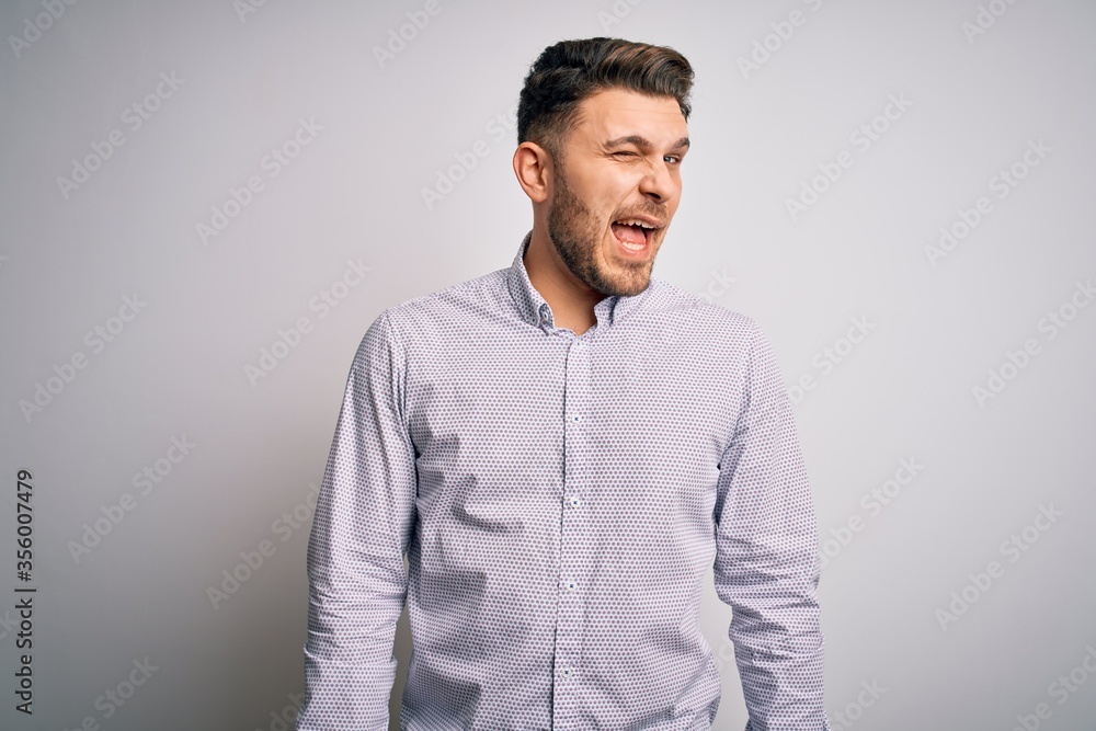 Young business man with blue eyes standing over isolated background winking looking at the camera with sexy expression, cheerful and happy face. Young business man with blue eyes standing over isolated background winking looking at the camera with sexy expression, cheerful and happy face.