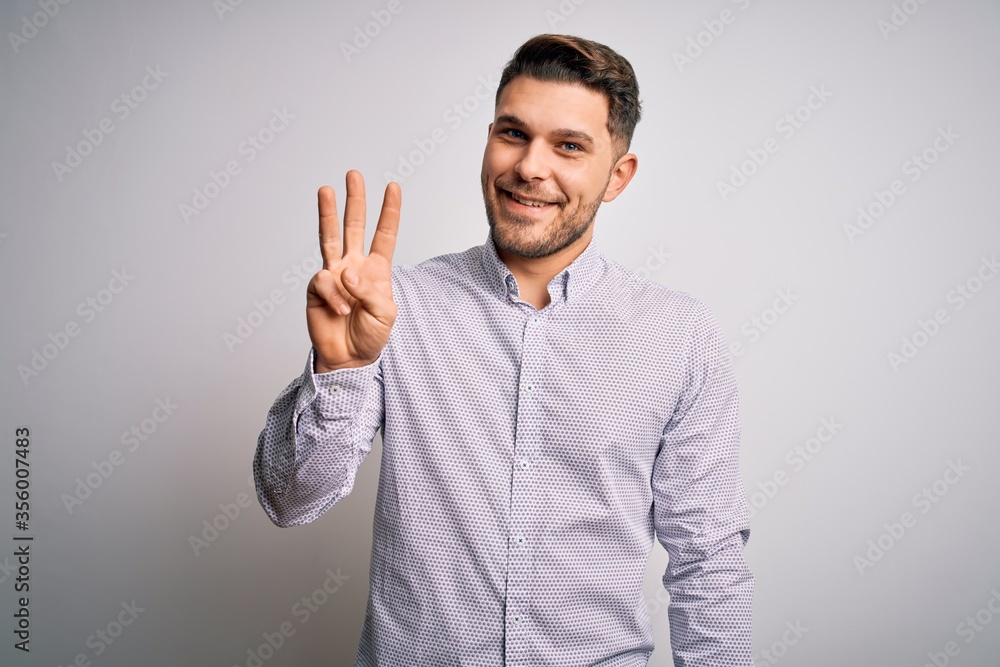 Young business man with blue eyes standing over isolated background showing and pointing up with fingers number three while smiling confident and happy. Young business man with blue eyes standing over isolated background showing and pointing up with fingers number three while smiling confident and happy.