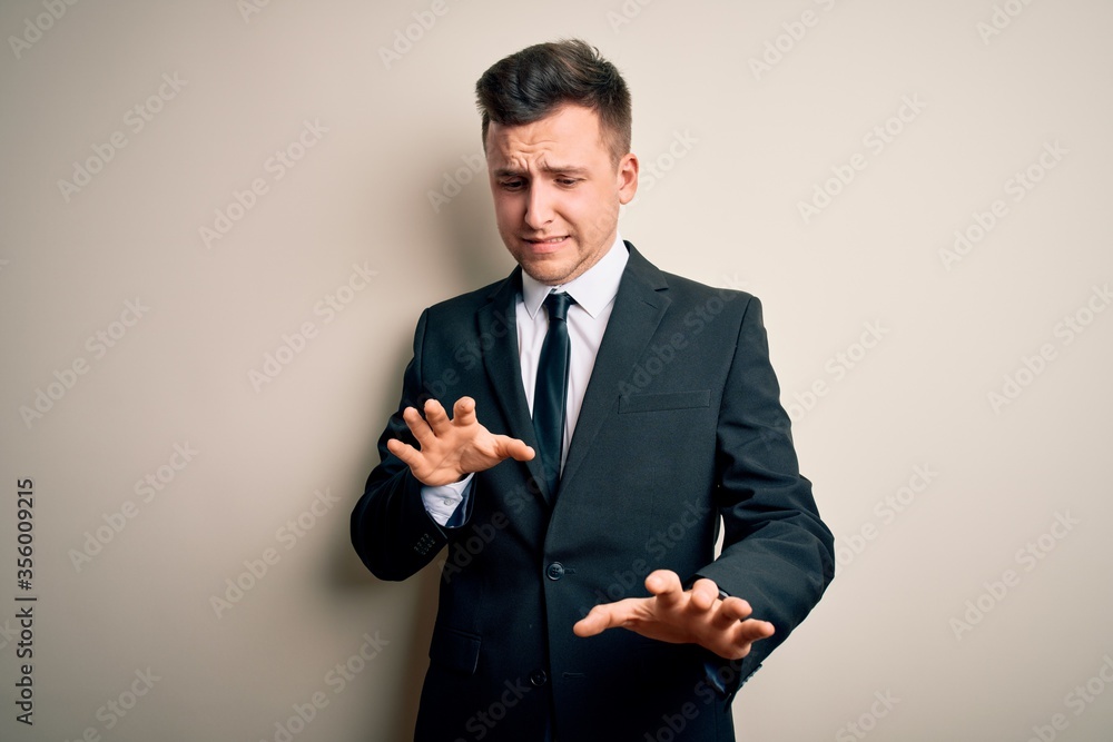 Young handsome business man wearing elegant suit and tie over isolated background disgusted expression, displeased and fearful doing disgust face because aversion reaction. Young handsome business man wearing elegant suit and tie over isolated background disgusted expression, displeased and fearful doing disgust face because aversion reaction.
