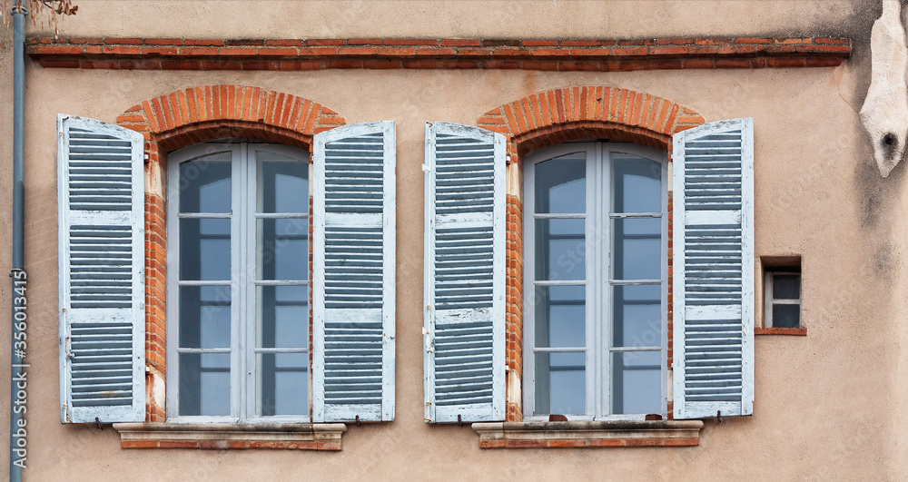 Windows with shutters on the wall of the old house Windows with shutters on the wall of the old house