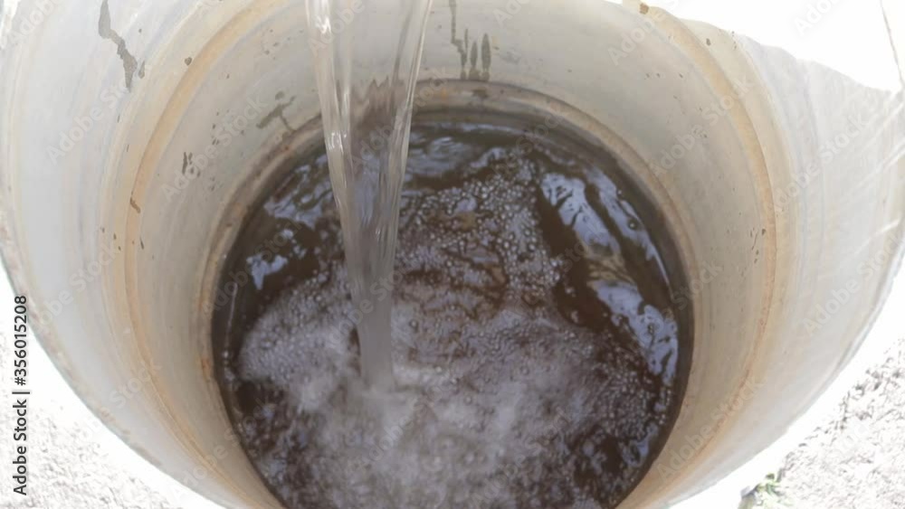 fill a bucket with water from a barrel Stock ビデオ Adobe Stock
