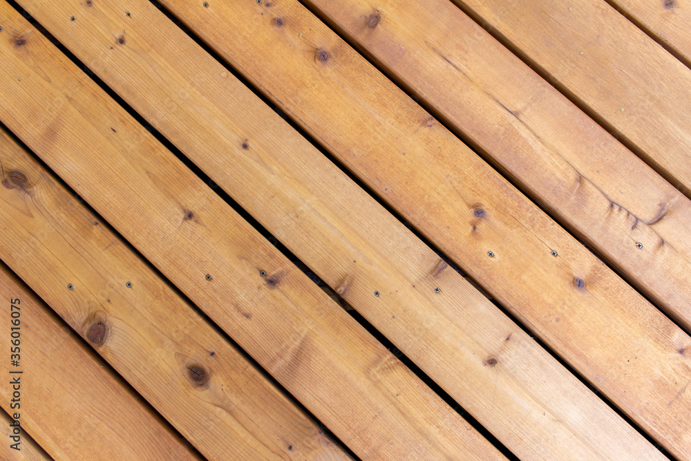 Close up abstract texture background of a newly constructed cedar wood deck floor, having a diagonal layout design, with copy space Close up abstract texture background of a newly constructed cedar wood deck floor, having a diagonal layout design, with copy space