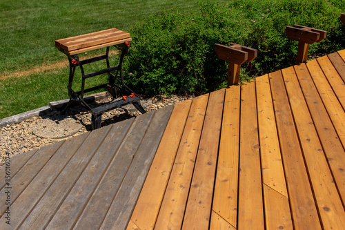 Cedar deck reconstruction with new wooden floor boards installed and partially constructed bench seating