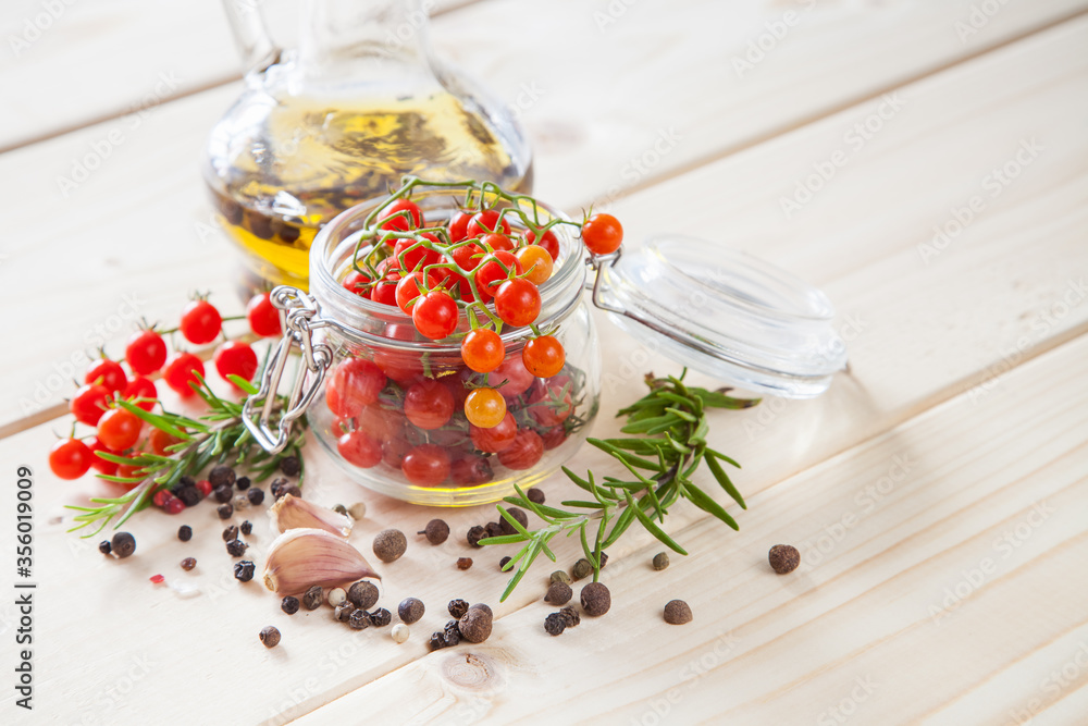 tomatoes in a jar, rosemary and garlic on a wooden background, selective focus tomatoes in a jar, rosemary and garlic on a wooden background, selective focus
