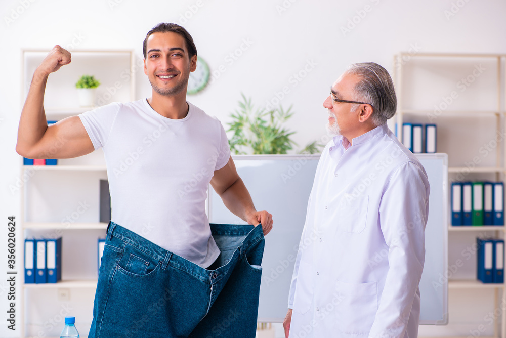 Obraz premium Doctor dietician and happy patient wearing large trousers