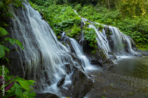 Waterfall landscape. Beautiful hidden waterfall in tropical rainforest. Nature background. Slow shutter speed, motion photography. Pucak Manik waterfall, Bali, Indonesia photo