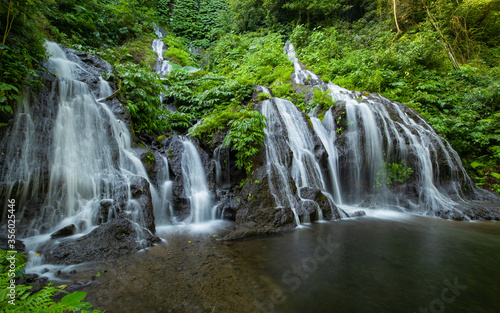 Waterfall landscape. Beautiful hidden waterfall in tropical rainforest. Nature background. Slow shutter speed, motion photography. Pucak Manik waterfall, Bali, Indonesia