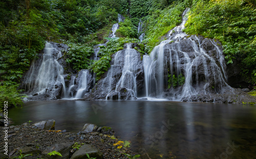 Waterfall landscape. Beautiful hidden waterfall in tropical rainforest. Nature background. Slow shutter speed, motion photography. Pucak Manik waterfall, Bali, Indonesia