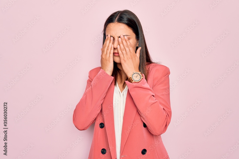 Young beautiful brunette businesswoman wearing elegant jacket over isolated pink background rubbing eyes for fatigue and headache, sleepy and tired expression. Vision problem Young beautiful brunette businesswoman wearing elegant jacket over isolated pink background rubbing eyes for fatigue and headache, sleepy and tired expression. Vision problem