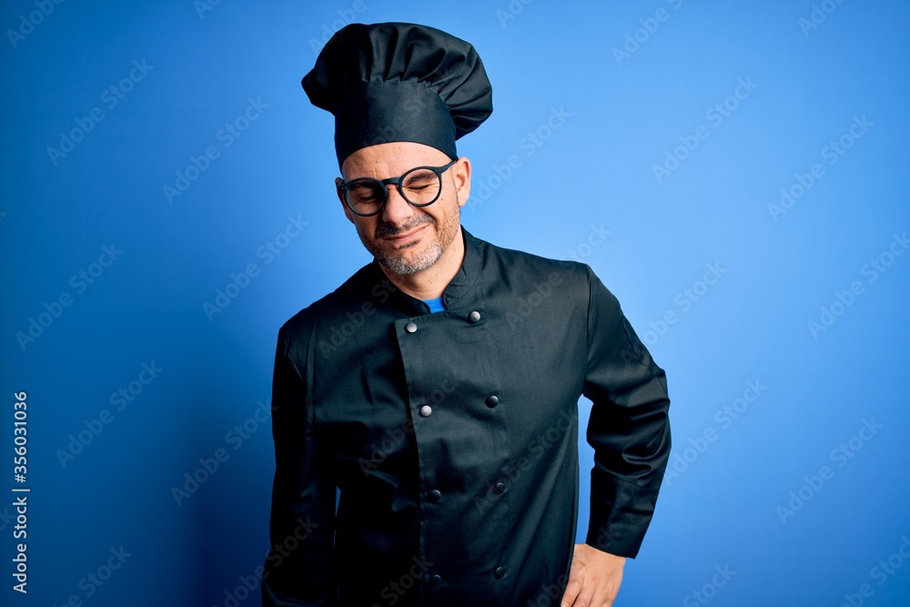 Young handsome chef man wearing cooker uniform and hat over isolated blue background Suffering of backache, touching back with hand, muscular pain Young handsome chef man wearing cooker uniform and hat over isolated blue background Suffering of backache, touching back with hand, muscular pain