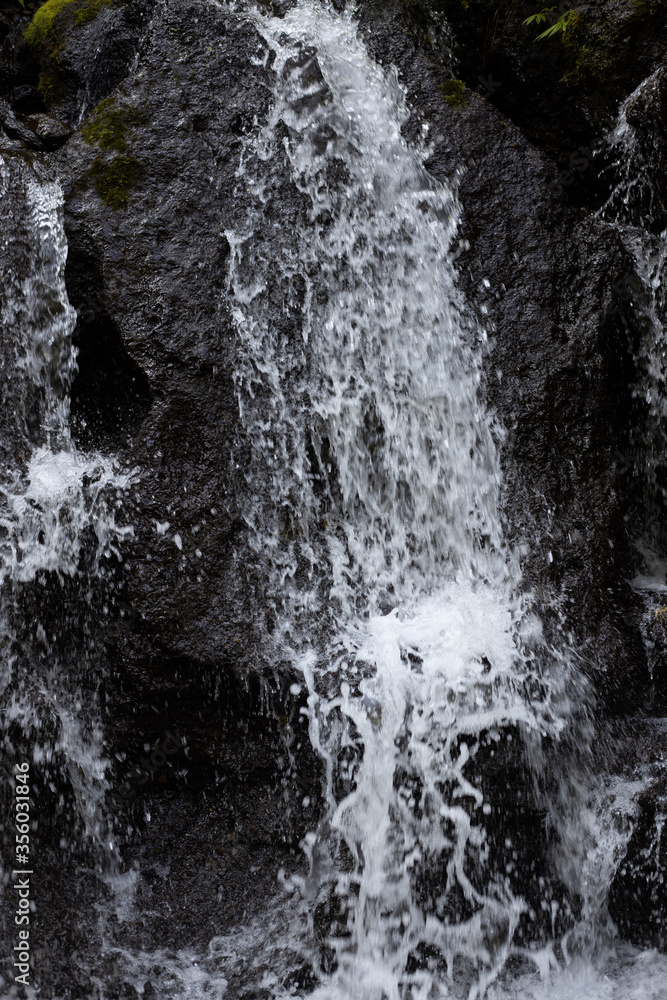 Close up of waterfall. Dynamic water flow. Waterscape background. Nature and environment concept. Pucak Manik waterfall Bali, Indonesia Close up of waterfall. Dynamic water flow. Waterscape background. Nature and environment concept. Pucak Manik waterfall Bali, Indonesia