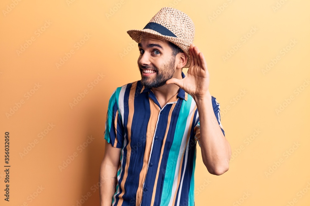 Young handsome man with beard wearing summer hat and shirt smiling with hand over ear listening an hearing to rumor or gossip. deafness concept. Young handsome man with beard wearing summer hat and shirt smiling with hand over ear listening an hearing to rumor or gossip. deafness concept.