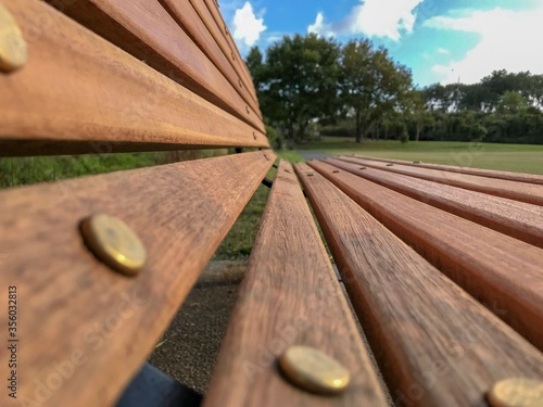 Empty wooden park bench perspective