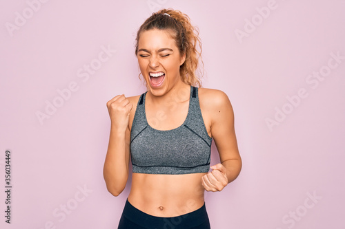 Young beautiful blonde sportswoman with blue eyes doing exercise wearing sportswear celebrating surprised and amazed for success with arms raised and eyes closed. Winner concept. © Krakenimages.com