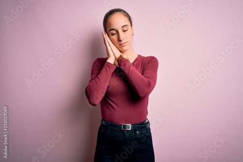 Young beautiful woman wearing casual t-shirt standing over isolated pink background sleeping tired dreaming and posing with hands together while smiling with closed eyes.