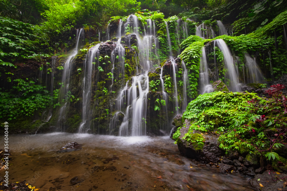 Waterfall landscape. Beautiful hidden waterfall in tropical rainforest. Nature background. Slow shutter speed, motion photography. Banyu Wana Amertha waterfall, Bali, Indonesia Waterfall landscape. Beautiful hidden waterfall in tropical rainforest. Nature background. Slow shutter speed, motion photography. Banyu Wana Amertha waterfall, Bali, Indonesia