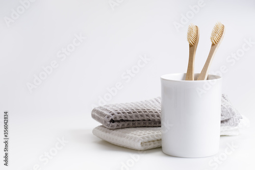 natural eco friendly toothbrush with wooden bamboo handle in a white cup photo