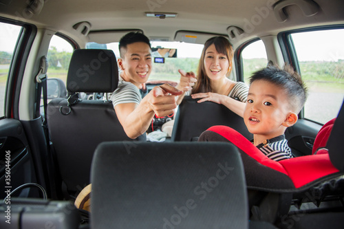 happy asian family sitting in the car