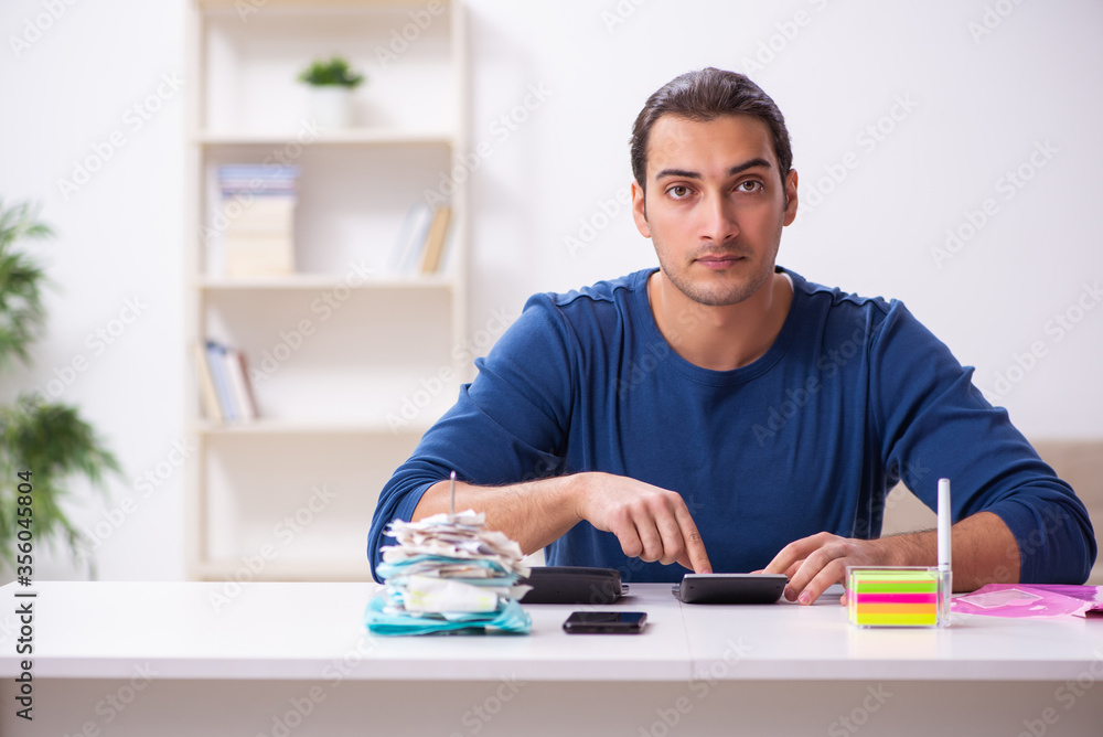 Young man in budget planning concept Young man in budget planning concept